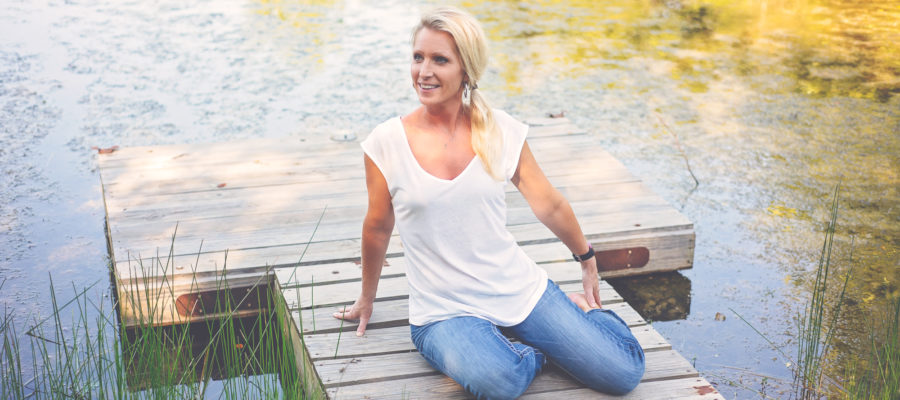 Self Care Woman sitting on dock in pond
